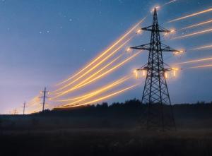 A power line tower at dusk with bright, streaking lights in the sky, resembling electricity flow.