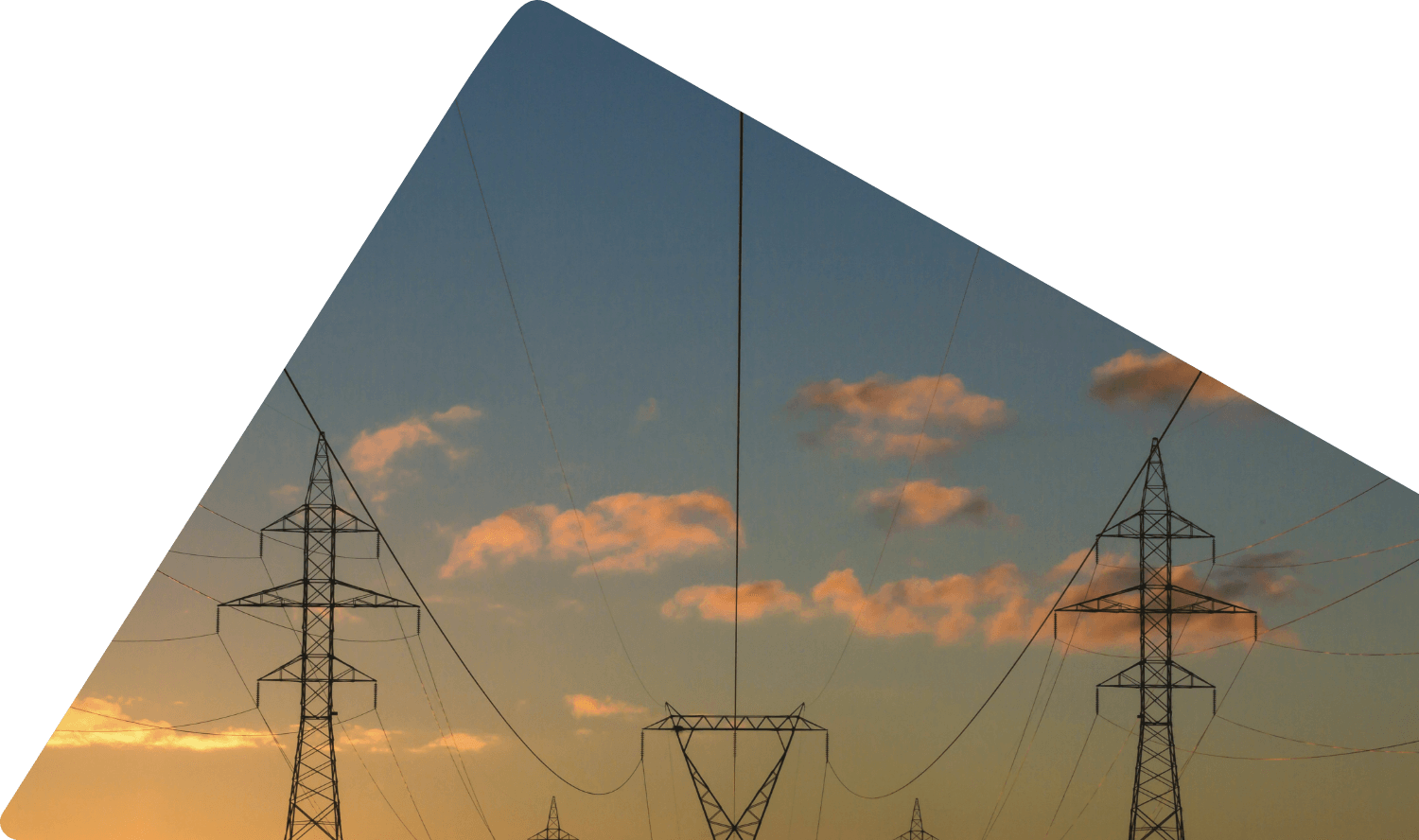 Silhouetted power lines and towers against a sunset sky with scattered clouds.